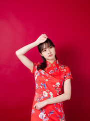 Beautiful asian woman wearing traditional cheongsam qipao dress suffering from headache desperate on red background.