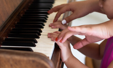 Fototapeta premium experienced master piano hand helps the student, close-up fingers