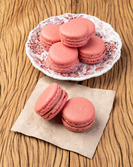Berry macarons on a plate over wooden table