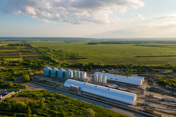 Aerial view of industrial ventilated silos for long term storage of grain and oilseed. Metal elevator for wheat drying in agricultural zone