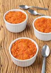Traditional brazilian pumpkin sweet dessert with spoons over wooden table