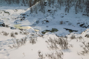 Winter landscape with trees and sky from the high rocky river bank