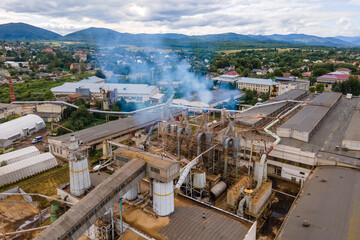 Aerial view of wood processing plant with smokestack from production process polluting environment at factory manufacturing yard