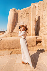 A blogger girl takes photos in the ruins of the grandiose Karnak temple in the ancient city of...