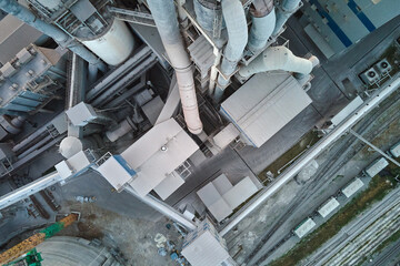 Cement plant with high factory structure and tower cranes at industrial production area. Manufacture and global industry concept