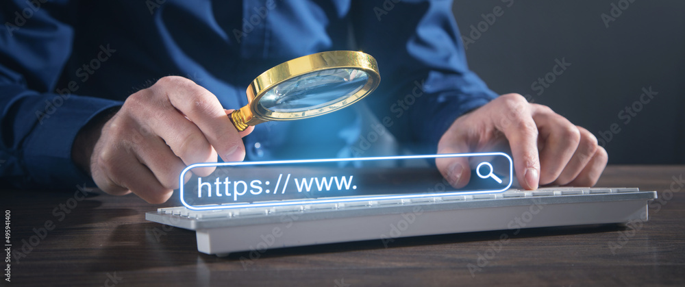 Canvas Prints male hands holding magnifying glass and typing in computer keyboard. internet search concept