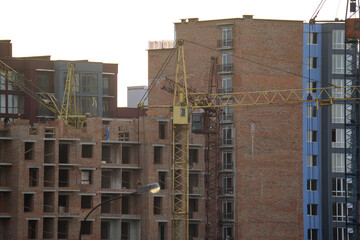 Tower cranes at high residential apartment buildings construction site. Real estate development