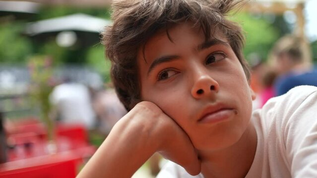 One young boy with contemplative expression a teenager kid thinking