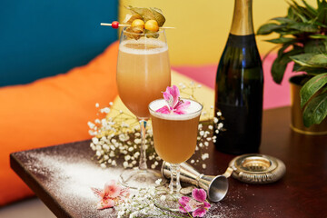 Beautiful cold cocktail and flowers on table