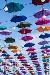 Fototapeta na wymiar Colored umbrellas on a blue sky background in sunny weather