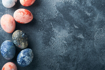 Easter eggs. Dyed Easter eggs with marble stone effect ref and blue color in rustic style on dark stone background. Easter background. Top view.