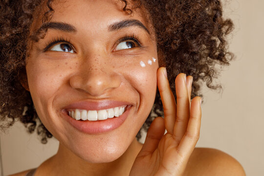 Young woman with cream on face in studio