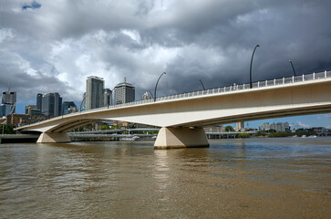 Victoria Bridge spanning the Brisbane River and skyline of the Brisbane business district under rain clouds