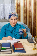 A female rabbi of the Kisui Rosh Reform Judaism congregation draws up an activity plan and drinks coffee.