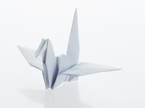 White origami paper crane on white background