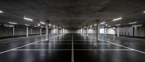 Poster Vooraanzicht van nieuwe lege ondergrondse parkeergarage met betonnen kolommen, glanzend asfalt en niemand binnen © alexandre zveiger