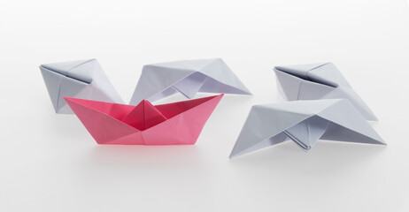 Pink paper boat and a lot of sinking ships