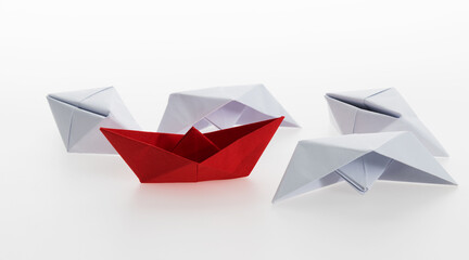 Red paper boat and a lot of sinking ships