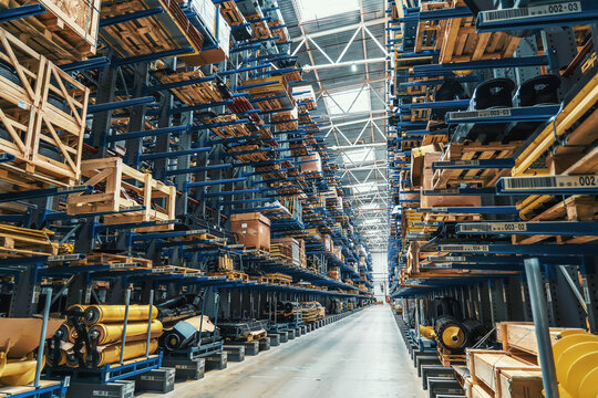 Modern distribution retail warehouse interior with many high shelves, boxes and goods on racks ready for delivery and shipping.