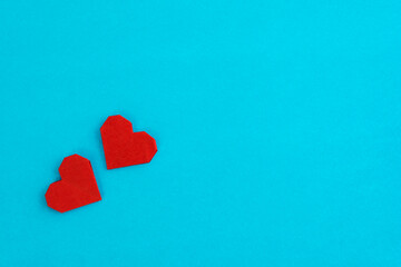 Fototapeta premium Red origami hearts on blue background
