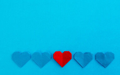 A row origami hearts on blue background