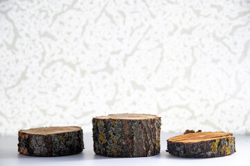 Moss-covered wooden podiums. White background. Chiaroscuro pattern, layout or stand.