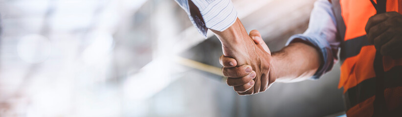 Two engineer shaking hands with deals and congratulations on success, panorama image use for cover...