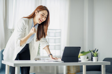 Happy excited Young asian businesswoman in the office working with a laptop computer, Yes great job.