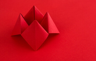 Origami paper fortune on red background