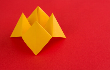 Origami paper fortune on red background