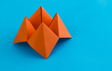 Origami paper fortune on blue background