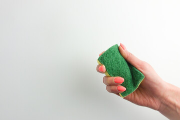 Woman hand holding a cleaning sponge. Domestic hygiene, housework concepts. Empty space for your design
