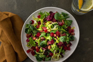 Warm salad with mixed salad with boiled beetroot and beans with spices, water with lemon, top view