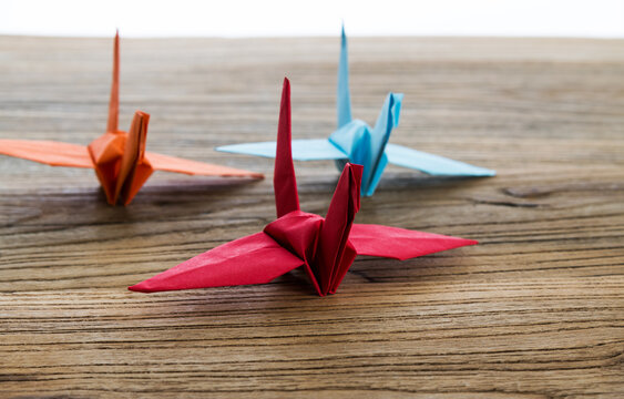 Origami paper cranes on wooden table