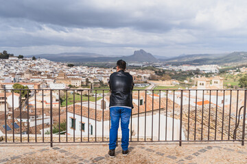 chico con barba en balcón de pueblo blanco andaluz