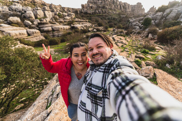 Pareja chico y chica tomándose fotos estilo selfie en entorno natural montañoso en Andalucía