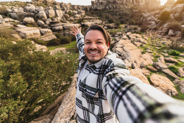 Chico gordo joven tomándose selfie en entorno natural de Andalucía mientras hace senderismo