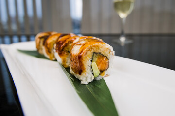 a sushi roll with eel and unagi sauce on a plate japanese cuisine