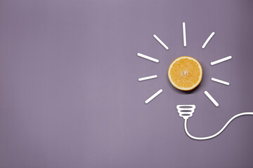 Creative thinking ideas and innovation concept. A ball of orange with a light bulb symbol on a purple background. Time for a healthy diet