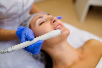Close-up of woman getting facial hydro microdermabrasion peeling treatment. Female at cosmetic...