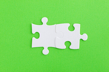 Two puzzle pieces on green background