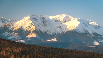 Szczyty Tatr rozświetlone promieniami wschodzącego słońca, zima, widok z przełęczy nad...
