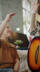 Fototapeta na wymiar Girl gives woman high five after guitar lesson