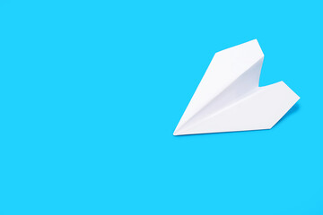 White paper airplane on a blue background. Paper origami in the form of a small airplane. Concept of travel or freedom of decision. Free space for text or advertisement