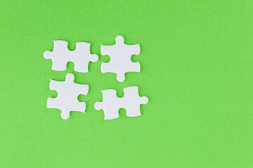 Four puzzle pieces on green background