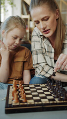 The girl and her mother are learning to play chess. They consider the fiuras