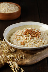 Oatmeal porridge with almonds and some ears of oats closeup. Healthy eating. Vegan and vegetarian food. Copy space.