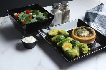 Salmon Pinwheel Stuffed with Spinach, served with Brussels Sprouts and Salad