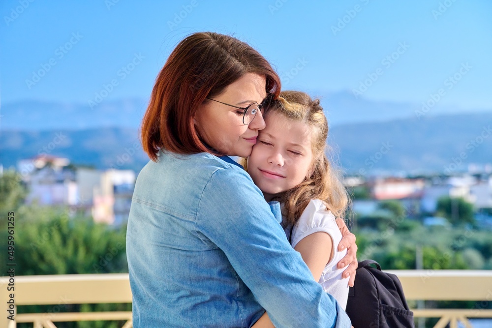 Poster Mom hugging her preteen daughter on the porch of the house