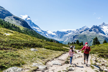Obraz premium Mother and children going for a walk in mountain surroundings.